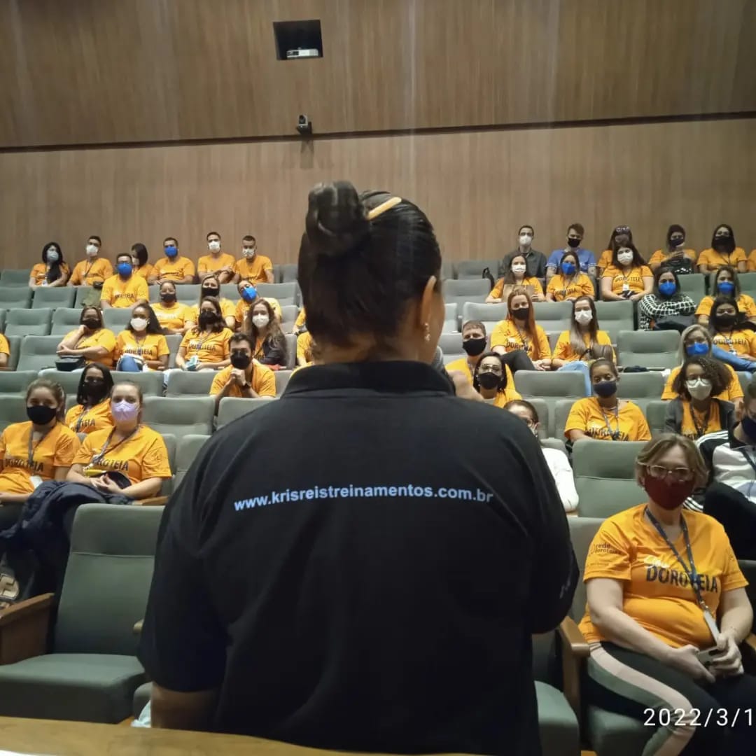 Instrutora em aula para turma em auditório